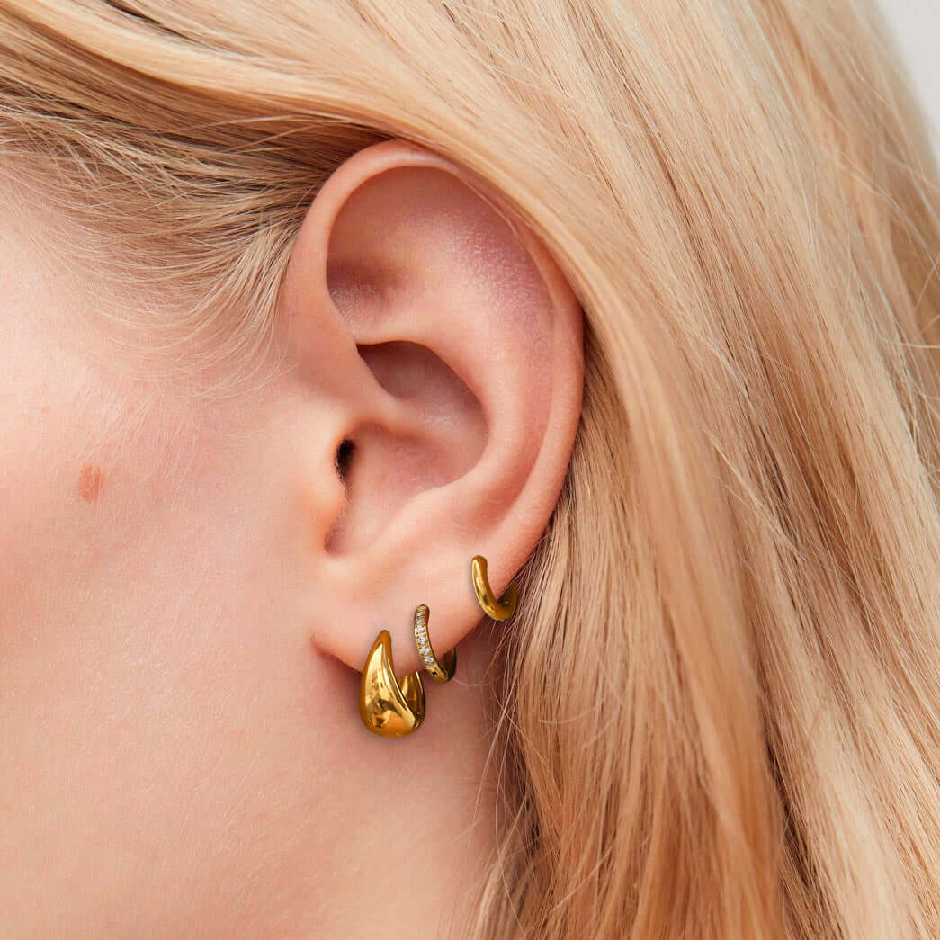 Сет обеци с 18К златно покритие, представени на ухото, стилни и хипоалергенни.