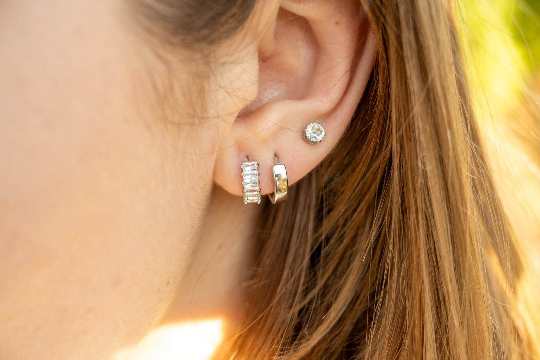 Облици Селенсе с три пиърсинг дупки, златисти и сребристи, елегантен модерен дизайн.