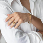 Elegant model showcasing 'Пръстен Lyna' ring in gold plating with a stylish white shirt.