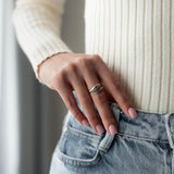 Жена носи ръчен пръстен Lyna с 18К златно покритие, съчетан с бели и сини дрехи.