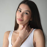 Сребърна гривна Eyes с кристал S925, показана от жена с дълга коса в бяло облекло.