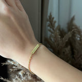 Златиста Гривна Спомен с 18К позлата – Персонализирана с Гравиране на ръка, пофотографирана на елегантен фон.