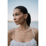 Колие Wave с мъниста и 18к златно покритие, модел бохо на жена на фона на природа.