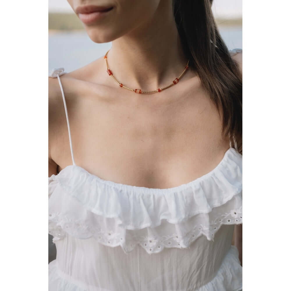 Колие Wave с мъниста, 18к златно покритие, носено с бяла риза, подходящо за лятото.