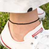 Гривна за глезен с черни мъниста, стилна и универсална, идеална за летни визии.