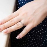 Елегантен пръстен от стомана Bone, показан на ръка с нежни нокти, идеален за ежедневно носене.