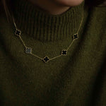 Колие Five Clover от сребро с 14К златно покритие, носено на човек в зелен пуловер.