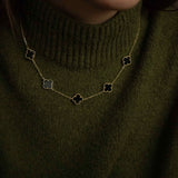 Колие Five Clover от сребро с 14К златно покритие, носено на човек в зелен пуловер.