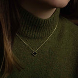 Колие One Clover от сребро с 14К златно покритие, носено от жена с зелена жилетка.