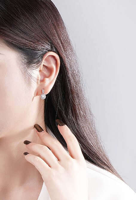 Сребърни обеци Разкош S925 с кристали, носени от жена, с дълга тъмна коса.