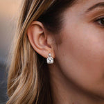 Елегантни обеци с блестящи камъни, изработени от сребро S925, носени на дамско ухо.
