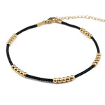 Black cord ankle bracelet with gold beads, made from medical steel, waterproof and stylish for daily wear.