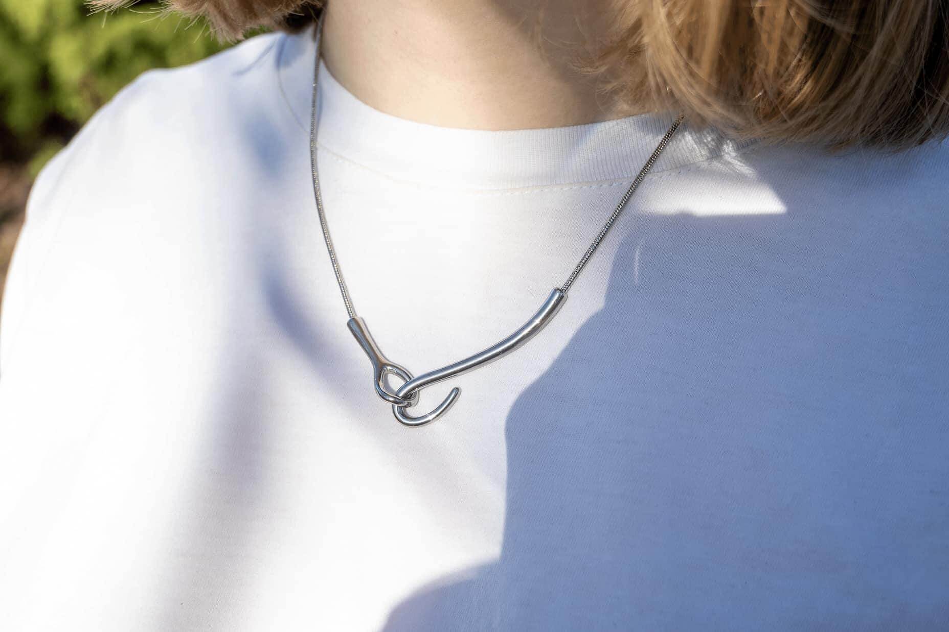 Колие от медицинска стомана, символизиращо свързаност в златисто и сребристо, елегантен дизайн.