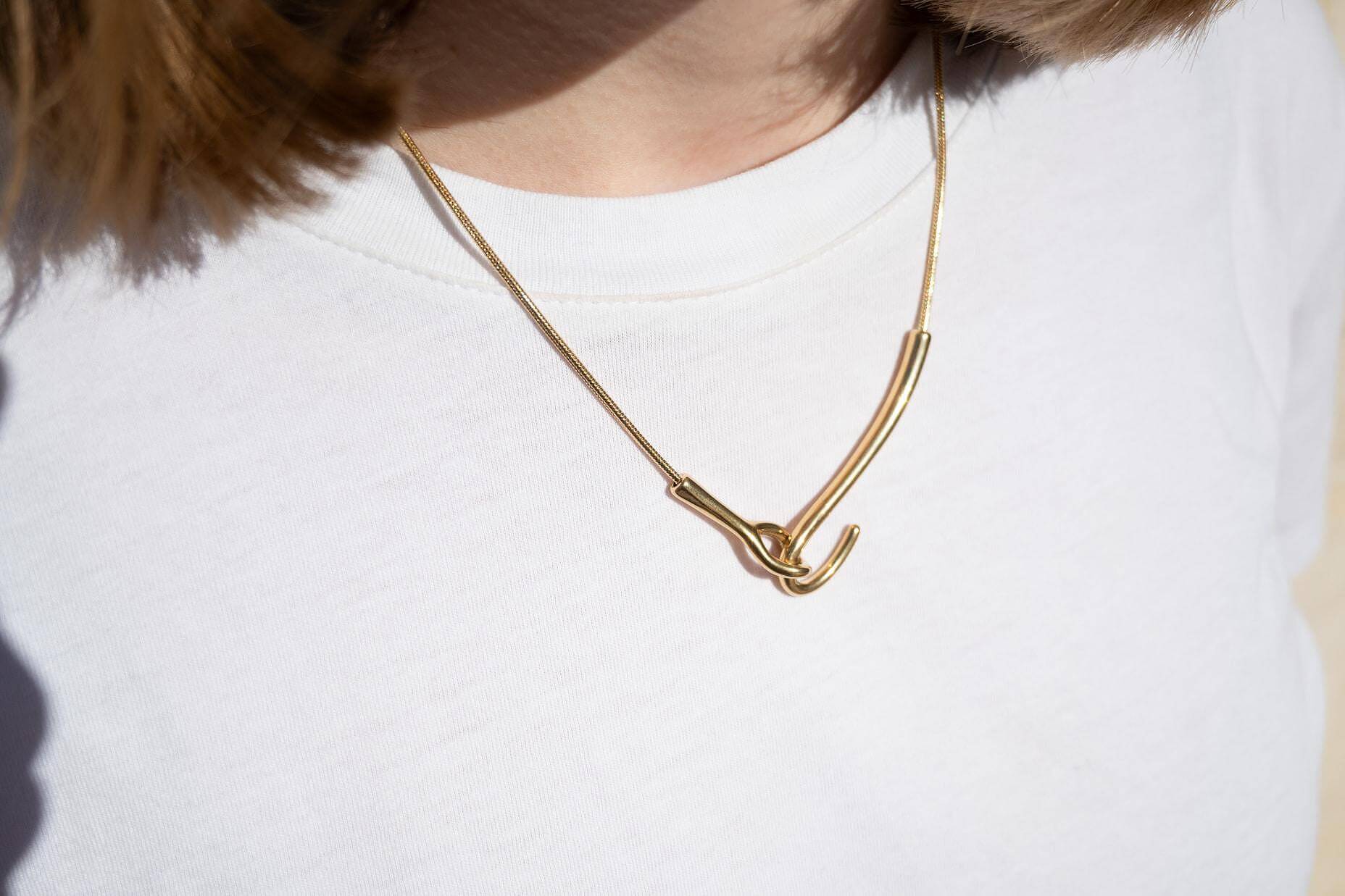 Колие от медицинска стомана, символизиращо свързаност в златисто и сребристо, елегантен дизайн.