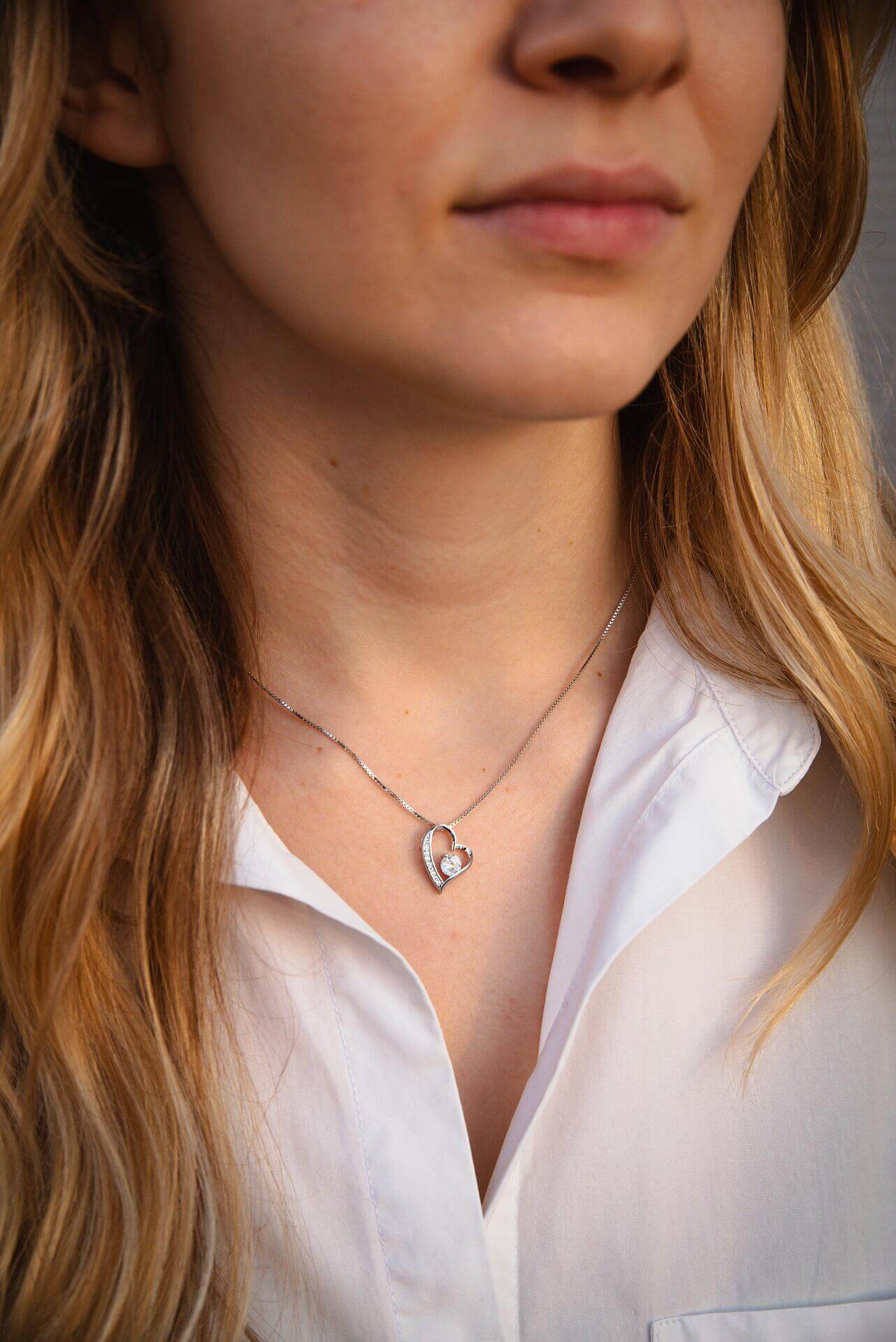 Сребърно колие с форма на сърце S925, носено от жена, с модерен и елегантен дизайн.
