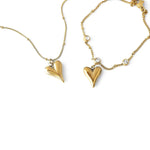 Златист комплект колие и гривна с висулки във формата на сърце, изработен от медицинска стомана.