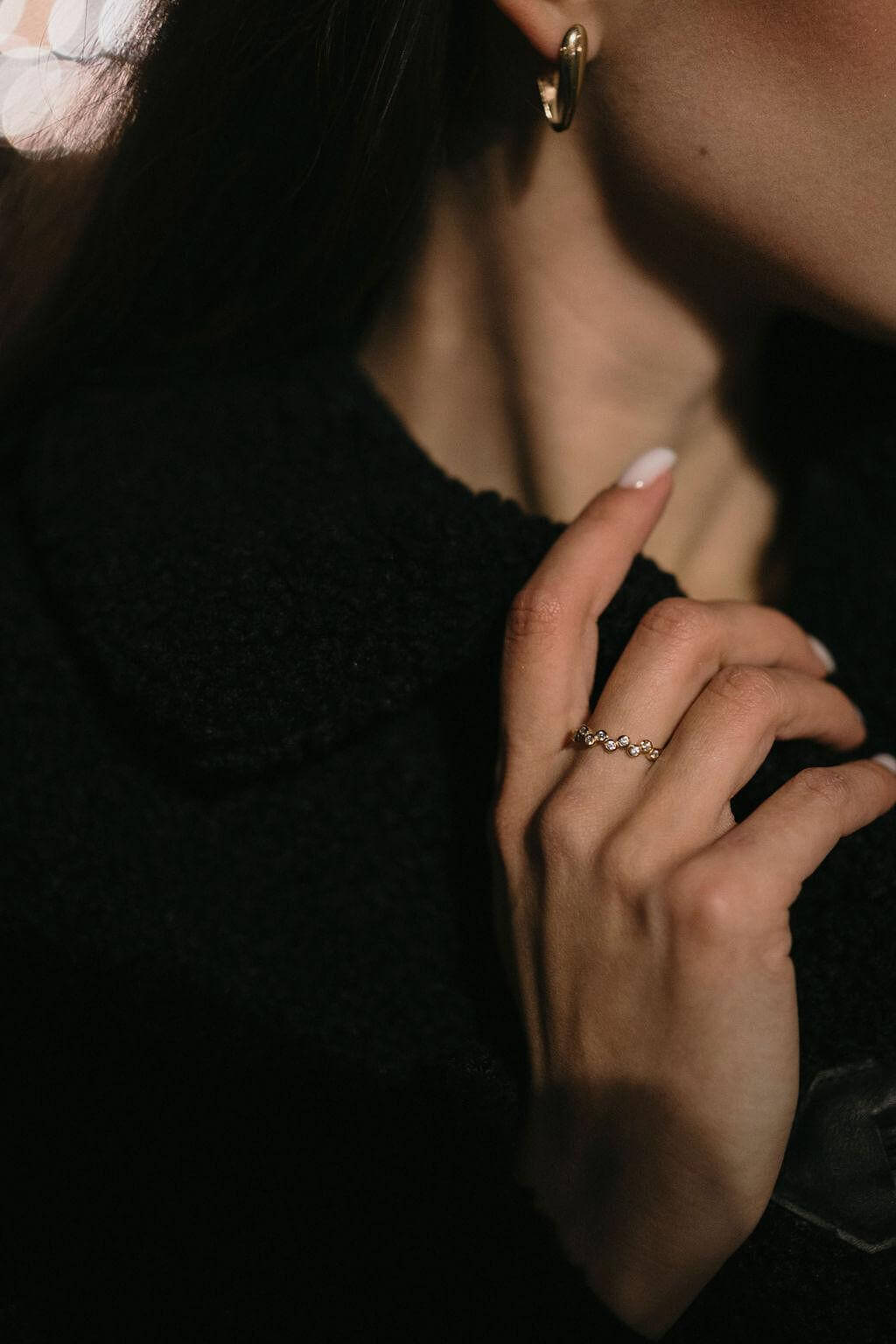 Изтънчени обеци V-Shape и стилен пръстен, носени от жена с елегантен аутфит.