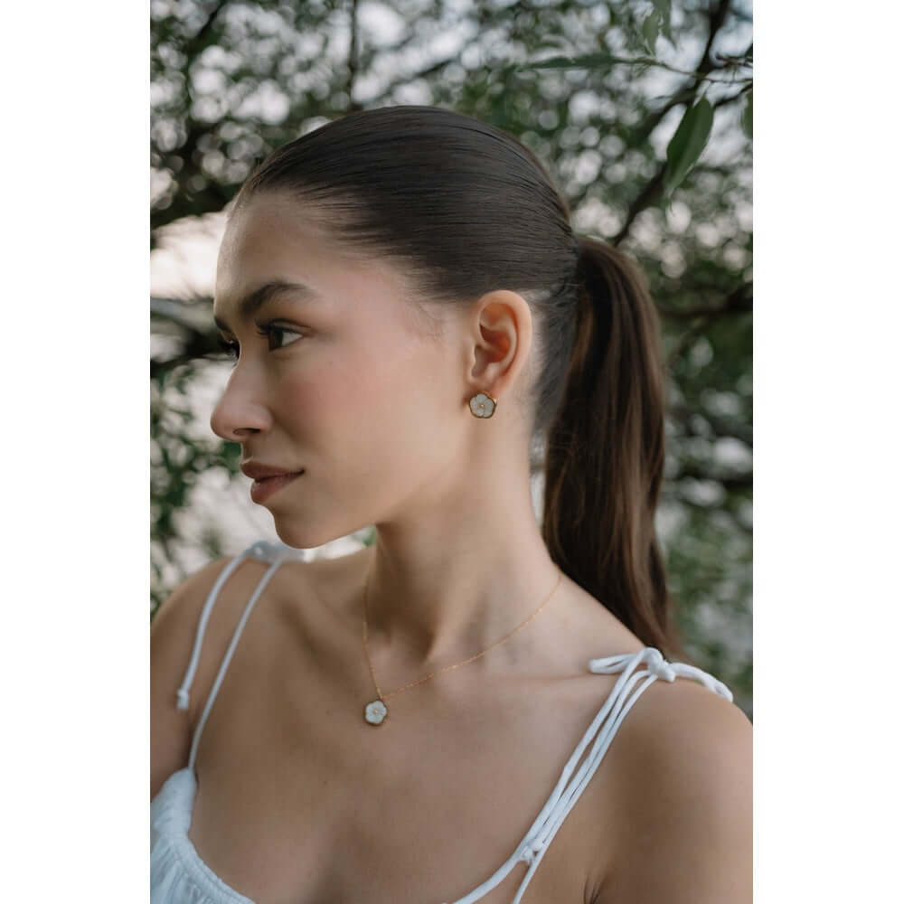 Обеци Цвете със Седеф, 18К позлата, в бохо стил на жена на фона на зеленина.