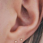 Снимка на обеци Golden Duo S925 с 18K златно покритие, носени в две пиърсинг дупки.