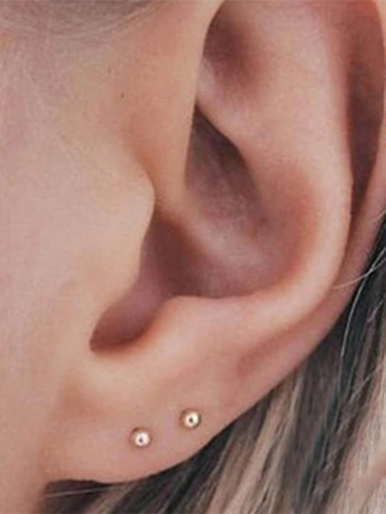 Снимка на обеци Golden Duo S925 с 18K златно покритие, носени в две пиърсинг дупки.