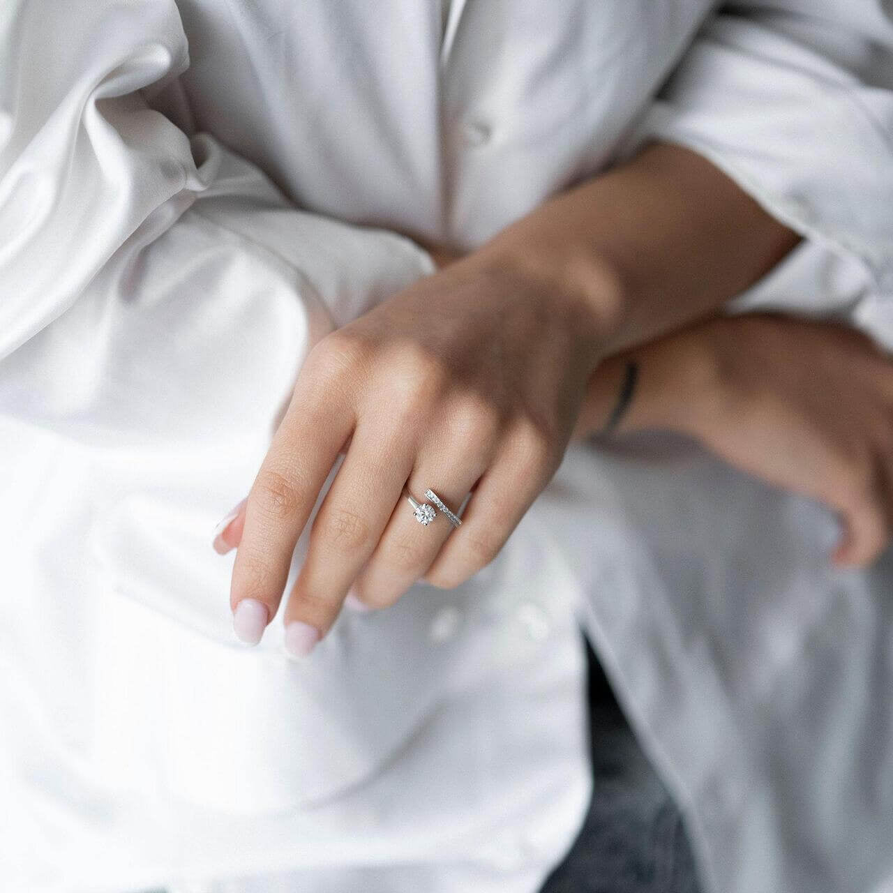 Woman wearing a shiny S925 silver ring with crystal and zirconia, posing in a stylish outfit.