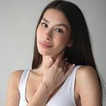 Сребърна гривна Eyes с кристал S925, показана от жена с дълга коса в бяло облекло.