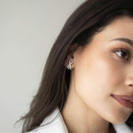 Сребърни обеци с 18K златно покритие S925, носени от жена, виждащи се на ухото.