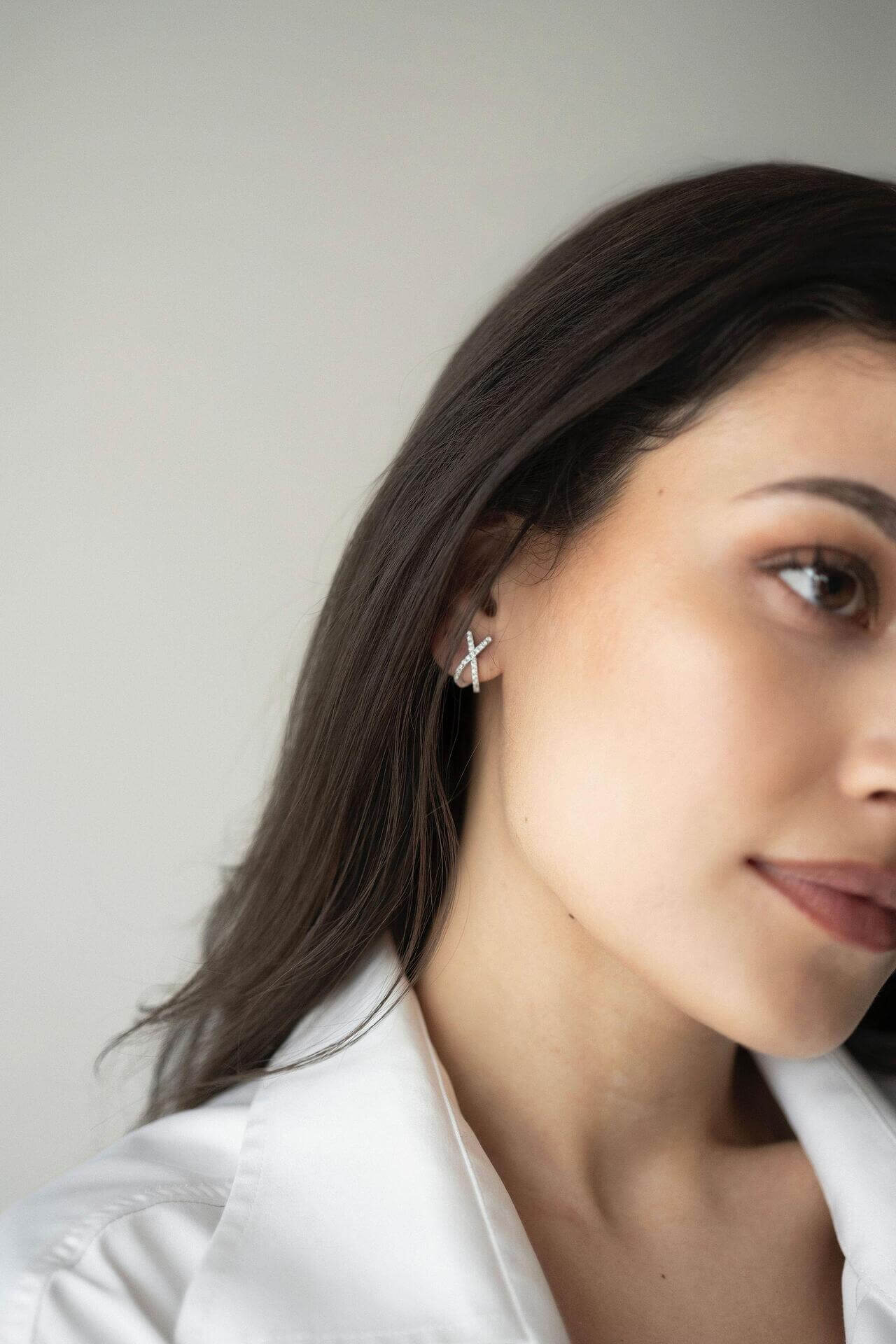 Сребърни обеци с 18K златно покритие S925, носени от жена, виждащи се на ухото.