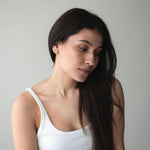 Woman wearing elegant S925 silver earrings with 18K gold plating, showcasing a timeless style and graceful beauty.