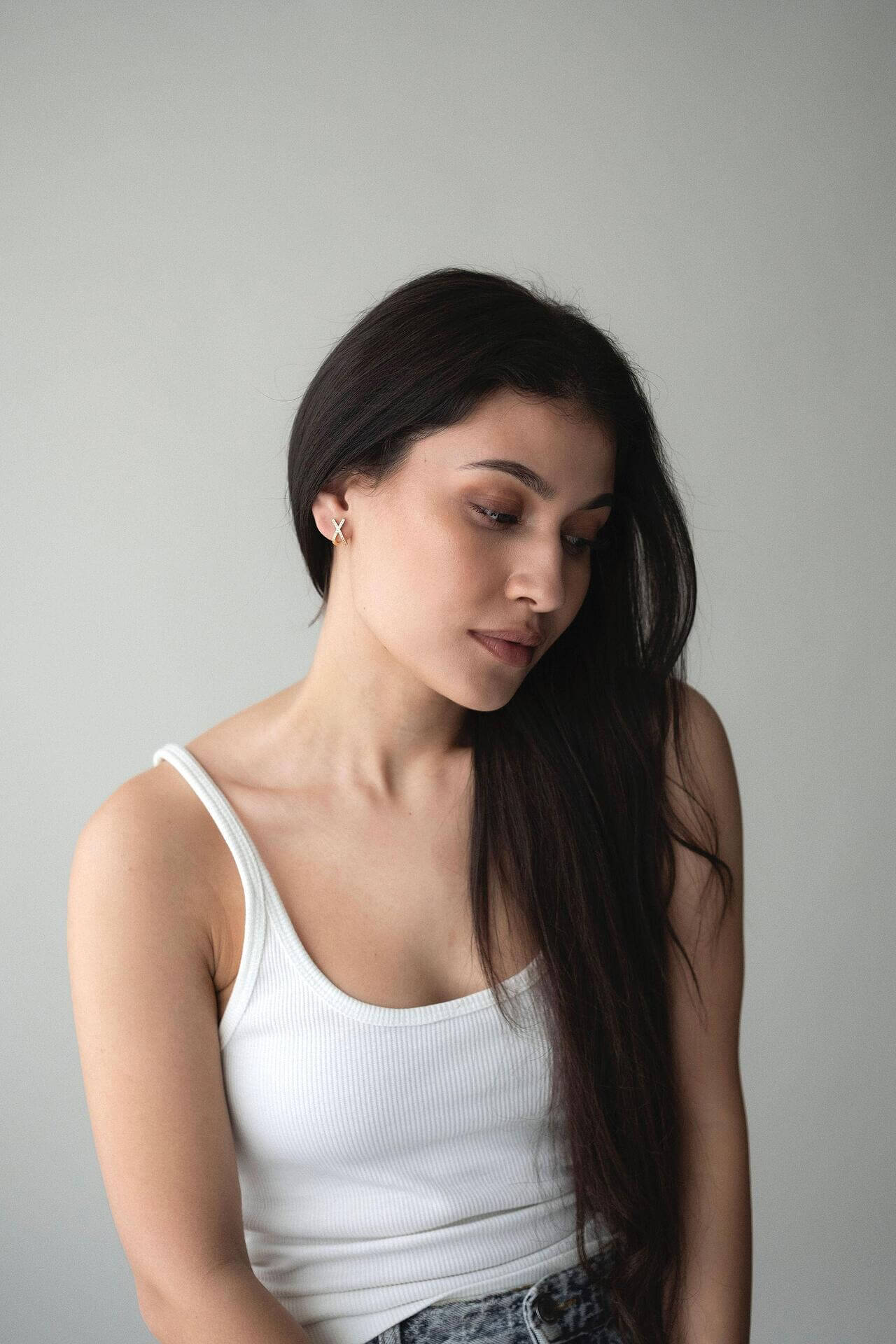 Woman wearing elegant S925 silver earrings with 18K gold plating, showcasing a timeless style and graceful beauty.