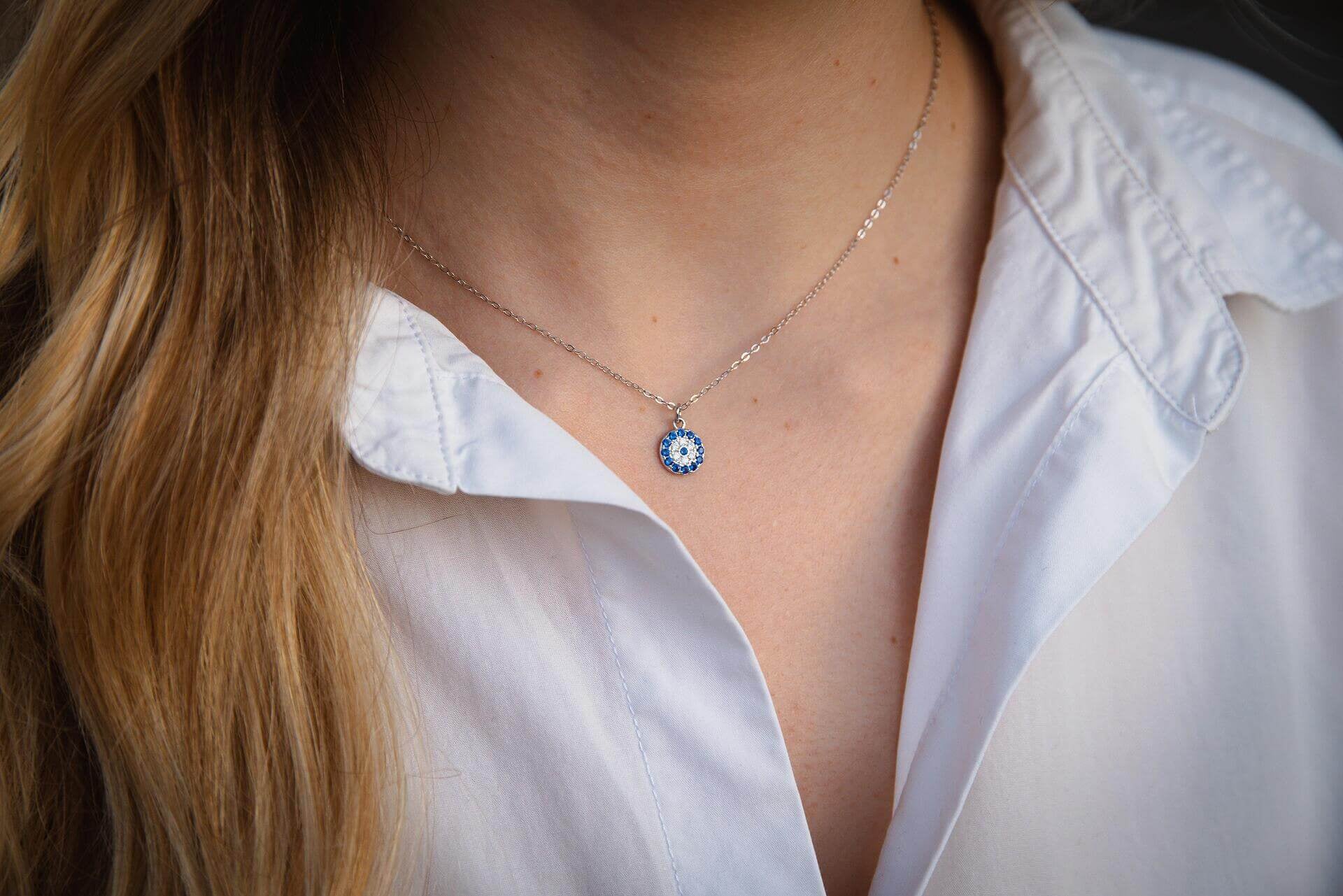 Сребърно колие с окото на Хамса, изработено от Сребро S925, носено на бяла риза.