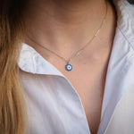 Сребърно колие с окото на Хамса, изработено от Сребро S925, носено на бяла риза.