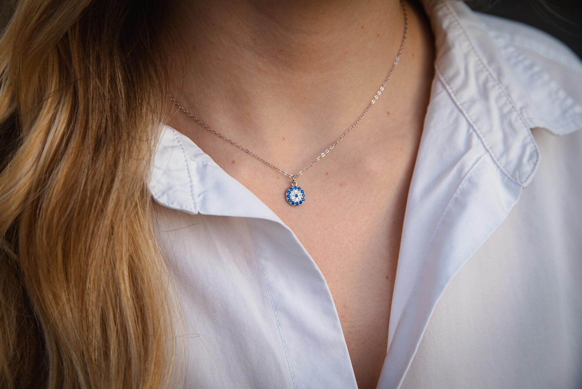 Сребърно колие с окото на Хамса, изработено от Сребро S925, носено на бяла риза.