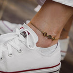 Гривна за глезен от медицинска стомана, модерна и елегантна, в комплект със спортни обувки.