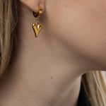 Стилистични висящи обеци с форма на златно сърце, подходящи за романтични поводи.