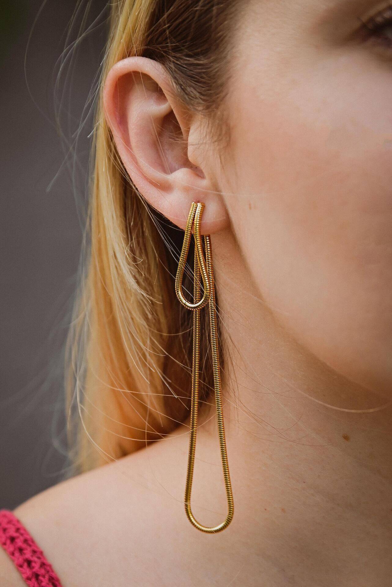 Модерни висящи обеци в златист цвят, съчетаващи елегантност и стил.