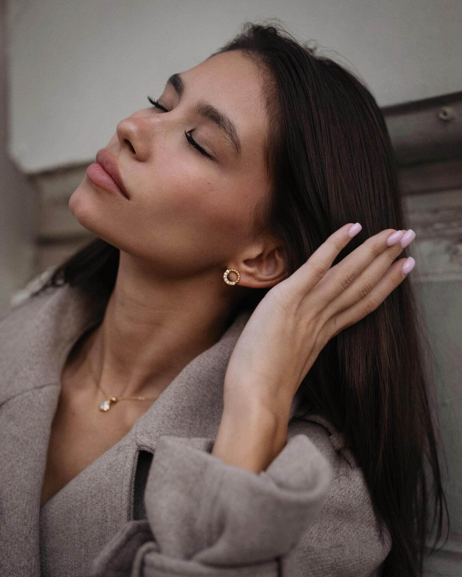 Модерна жена с дълга коса, носеща златисти обеци "Хибрид" с 18K златно покритие.