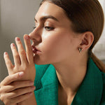 Златисти обеци модел Сърце, представени от жена с изтънчен стил и елегантен вид.