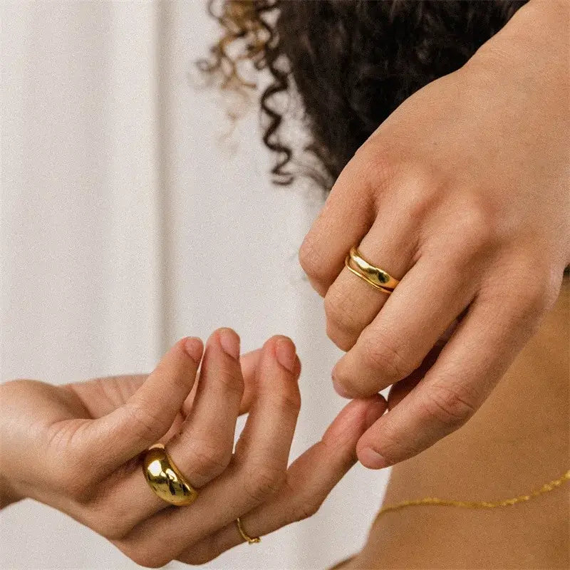 Детайл на златисти пръстени "Gratia" на ръце, с елегантен дизайн и 18K златно покритие.